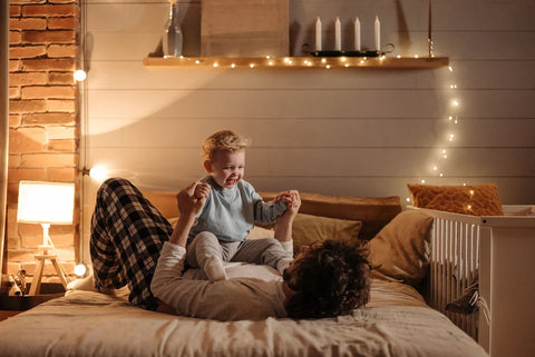 A happy family playing on a bed.